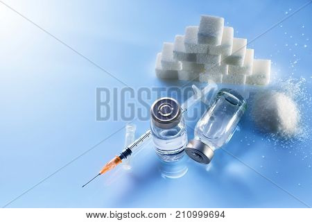 Insulin Vials And Syringe On Blue Table Top