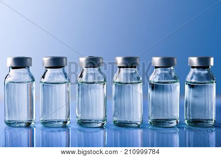 Row Of Vials On Blue Table And Blue Background Front View