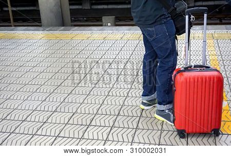 Closeup Legs Of Tourist Man With Small Red Luggage Waiting For The Japan Subway To The Airport At Nu