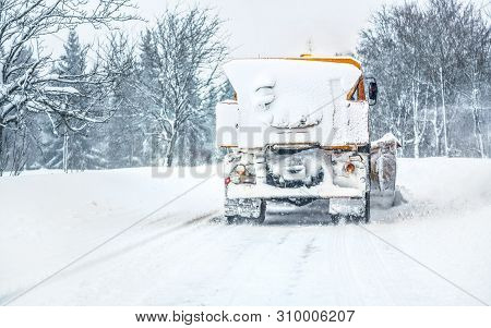 Orange Highway Maintenance Gritter Plough Truck Completely Covered With Snow, Cleaning Forest Road, 