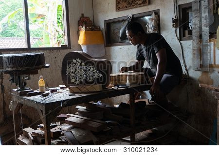 Gianyar,bali/indonesia-may 30 2019: A Guitar Craftsman Creating A Sketch On The Guitar Body At The G