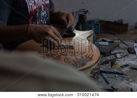 Gianyar,bali/indonesia-may 30 2019: A Classical Guitar Craftsman Is Pairing Guitar Strings To His Gu