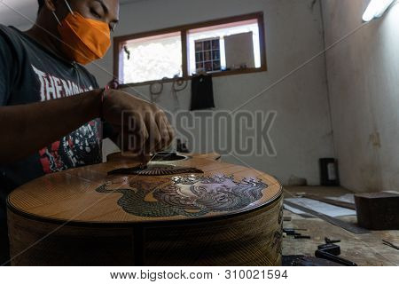 Gianyar,bali/indonesia-may 30 2019: A Classical Guitar Craftsman Is Pairing Guitar Strings To His Gu