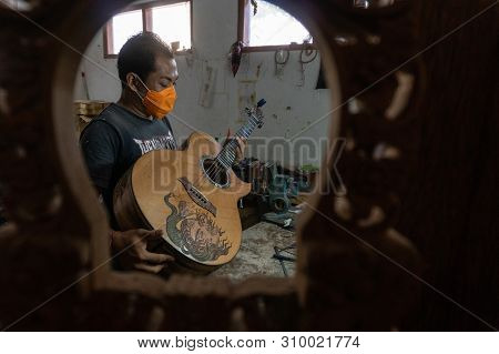 Gianyar,bali/indonesia-may 30 2019: A Classical Guitar Craftsman Is Pairing Guitar Strings To His Gu