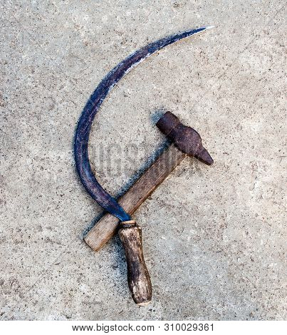 Sickle And Hammer (serp I Molot). Communist Symbol. Farm And Worker Tools On The Concrete Surface.