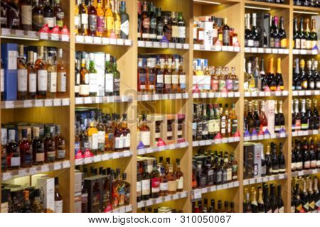 Large Wine Racks. Many Different Alcoholic Beverages. Luxury Enoteca. The Photo Is Blurry. Close-up.