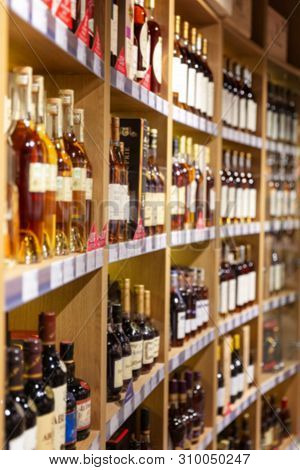 Large Wine Racks. Many Different Alcoholic Beverages. Luxury Enoteca. The Photo Is Blurry. Close-up.