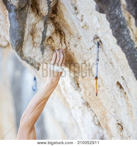 Climber's Hand Gripping Handhold On Cliff