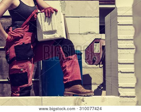 Unrecognizable Woman Working On Construction Site, Building House, Installing Gray Airbricks. Indust