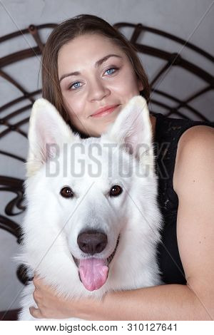 Young Attractive Caucasian Woman Embrases Expressive Dog Of Big Swiss Shepherd Breed. Beautiful Fema
