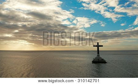Catholic Cross In Sunken Cemetery In The Sea At Sunset, Aerial Drone. Large Crucafix Marking The Und
