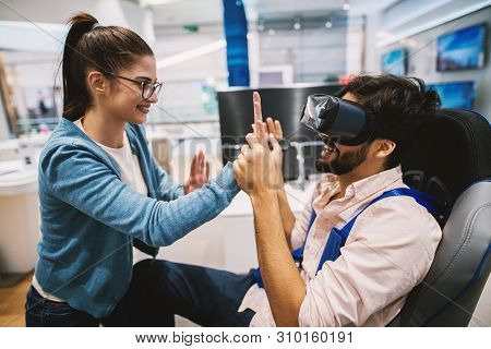 Joyful Attractive Modern Couple Having Fun Testing Vr In The Electronic Store.