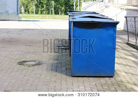 Metal Garbage Containers Are Arranged In A Row. Collection Of Household Waste, Sorting. The Concept 