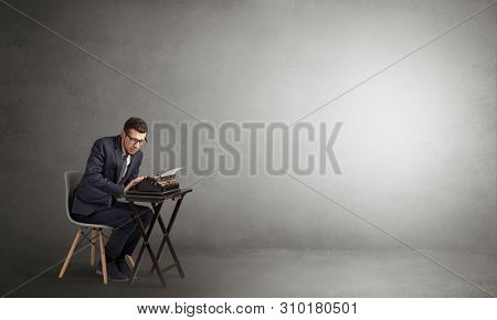 Man working hard on a typewriter in an empty space
