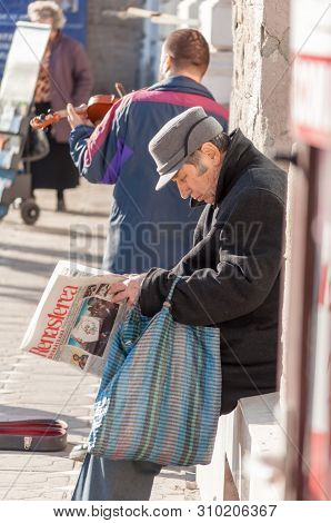 Timisoara, Romania - March 14, 2016: Man Reading A Newpaper (renasterea Banateana) On The Street. Re