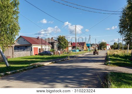 Russian Village In Summer. View Of The Village Road With Traditional Wooden Houses Along The Street.