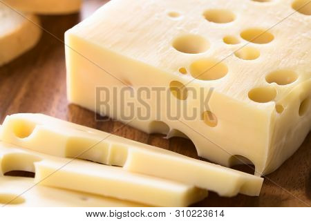 Piece Of Emmental, Emmentaler Or Emmenthal Cheese On Wooden Plate (selective Focus, Focus One Third 