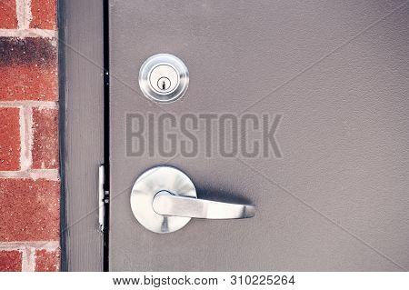 Modern New Metallic Grey Shiny Keyhole On Door Background. Front View Of Key Lock And Doorhandle By 