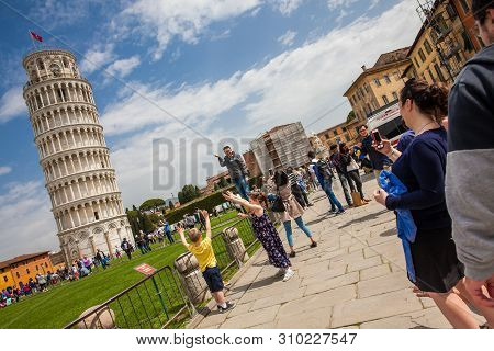 Pisa, Italy - April, 2018: Tourists Posing And Taking Pictures In Front Of The Famous Leaning Tower