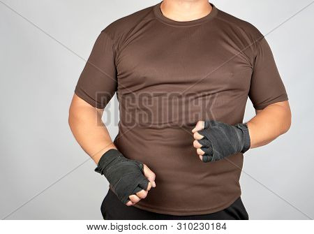 Adult Athlete In Brown Clothes With Bandaged Hands Black Textile Sports Bandage On A White Backgroun