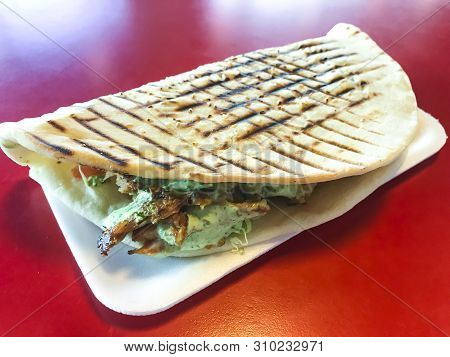 Spicy Turkish Doner Kebab Filled With Roasted Meat, Fresh Salad  And Garlic Sauce In Toasted Tortill