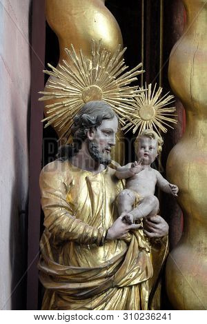 BRONNBACH, GERMANY - JULY 07, 2018: Saint Joseph holding baby Jesus, statue on the main altar in Cistercian Abbey of Bronnbach in Reicholzheim near Wertheim, Germany