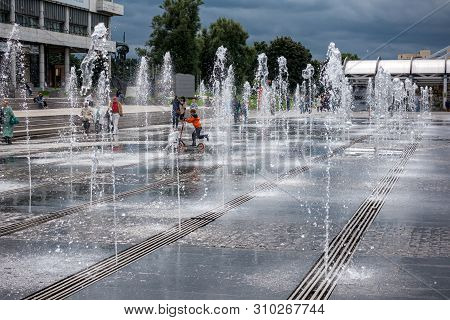 Moscow,museon Park,september 4,2016: Boy Fun Riding A Scooter Between The Jets Of Water In The Fount