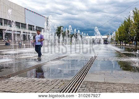 Moscow,museon Park,september 4,2016: Smiling Adult Man Are Walking Between The Jets Of Water In The 