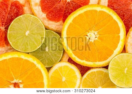 Four Slices Of Citrus Fruits, Closeup Background.