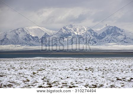 Waters Of Son-kul Lake On The Background Of Snow-capped Mountains And Sky With Clouds. Traveling In 