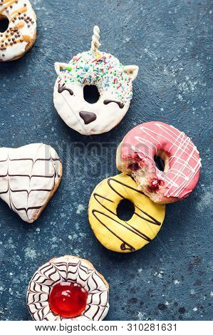 Frosted Donuts With Bite Missing On Dark Background.