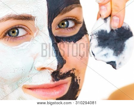 Woman With Clay Carbo Black Mask On One Half Face And White Mud On Second Half. Girl Removing Cosmet