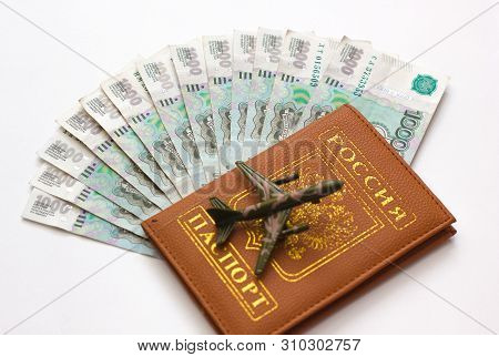 Russian Money And Passport On White Background, Close-up, Passport And Money Fan In Hand. Travel Age