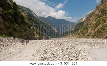 A Group Of Trekkers In Riverbed On Manaslu Circuit With View Of Mount Manaslu Range 8 156 Meters. Hi