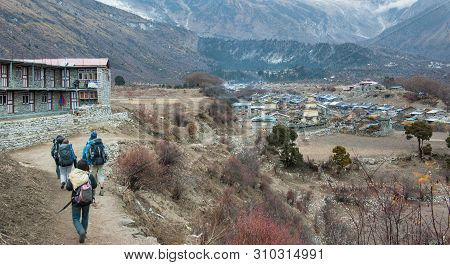 A Group Of Trekkers Heading To Samagau Village On Manaslu Circuit With View Of Mount Manaslu Range (
