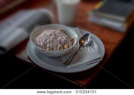 Healthy Breakfast On Wooden Table, Selective Focus, With Books And Newspaper In The Background, Sugg