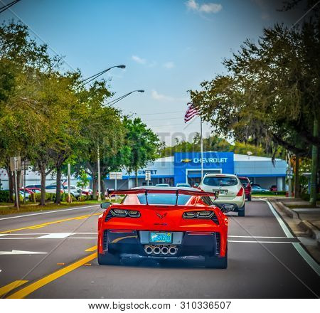 Florida, Usa - February 24, 2019: Red Corvette Seen From Behind With Chevrolet Dealership On The Bac