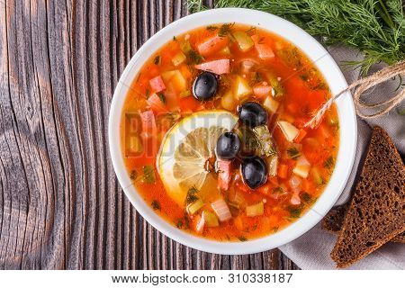 Traditional Russian Meat Soup Solyanka In Bowl On Rustic Wooden Table