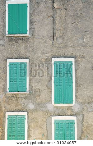 grÃ¼ne FensterlÃ¤den auf eine Fassade des grauen Hauses geschlossen.