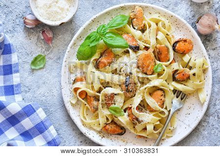 Tagliatella Pasta With Mussels And Cream Sauce On The Kitchen Table. View From Above.