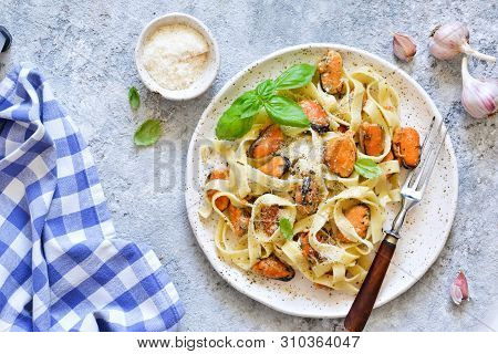 Tagliatella Pasta With Mussels And Cream Sauce On The Kitchen Table. View From Above.