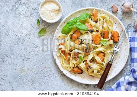 Tagliatella Pasta With Mussels And Cream Sauce On The Kitchen Table. View From Above.