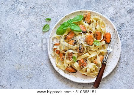 Tagliatella Pasta With Mussels And Cream Sauce On The Kitchen Table. View From Above.