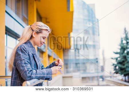 Young Woman Playing Origami Birds, White Cranes In Hands Against Sky Reflection In A Window