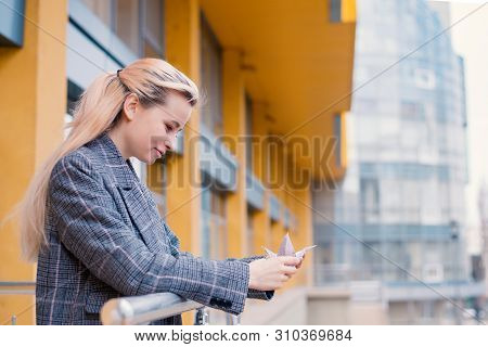 Young Woman Playing Origami Birds, White Cranes In Hands Against Sky Reflection In A Window