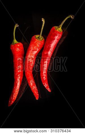 Top View Closeup Hot Red Hili Peppers On Black Glass