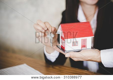 Real Estate Agent With House Model And Keys