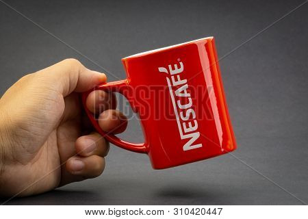 Kuala Lumpur, Malaysia - July 03, 2019; Promotional Red Nescafe Mug On Dark Background. Selective Fo