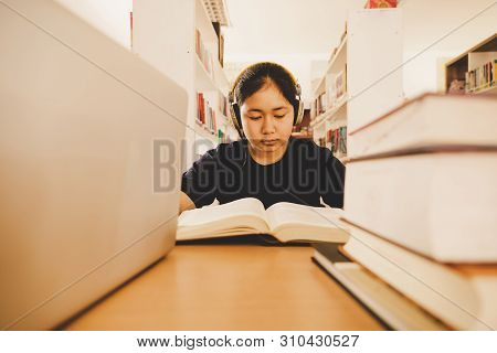 In The Library - Young Girl Student With Books Working In A High School Library.