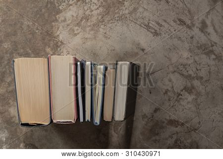 Lots Of Colourful Thick Open Books Stand On A Dark Background